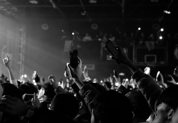 ライブ会場でアーティストを撮影する観客